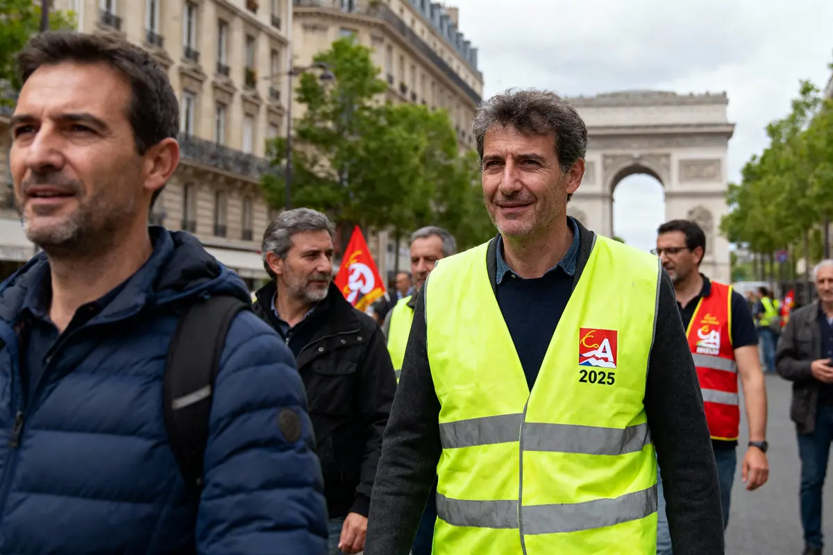 Manifestants portant des gilets jaunes et rouges à Paris, Arc de Triomphe en arrière-plan.