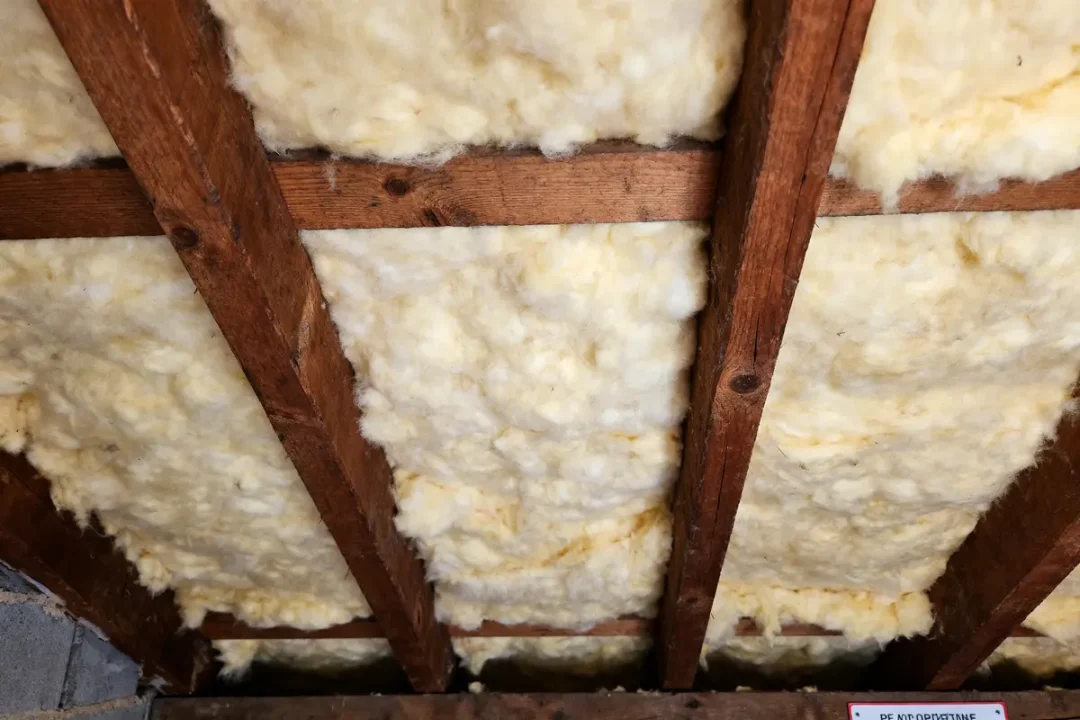 Isolant en laine minérale entre poutres en bois d'un plafond ou toiture.