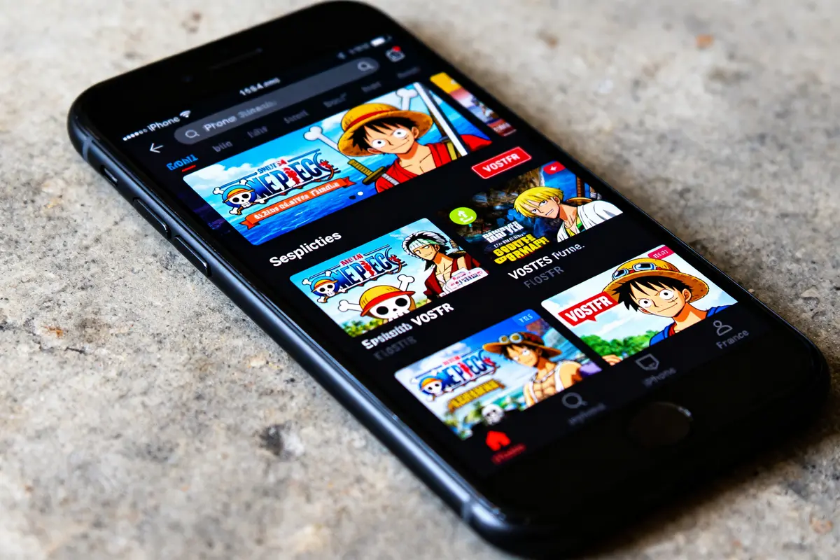 Écran d’iPhone affichant des épisodes de l’anime One Piece sur une application de streaming vidéo.