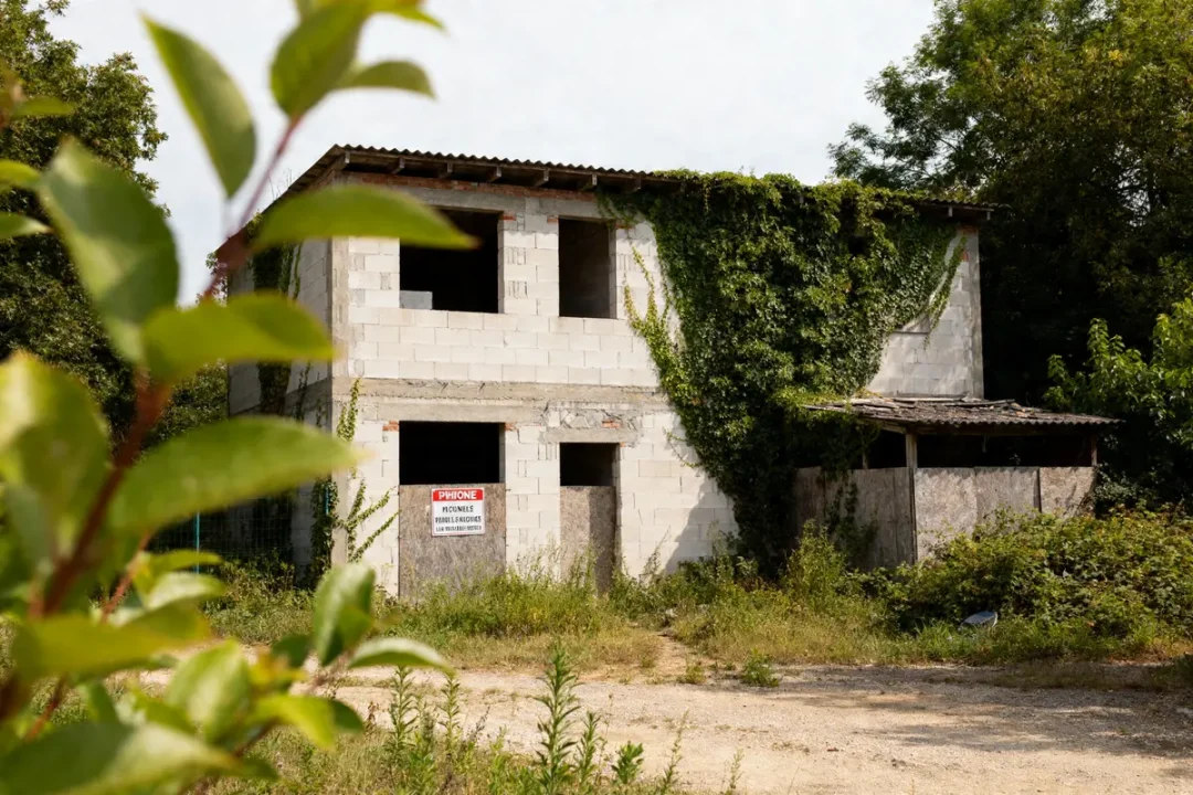 Bâtiment abandonné envahi par la végétation, exemple de construction illégale de plus de 10 ans