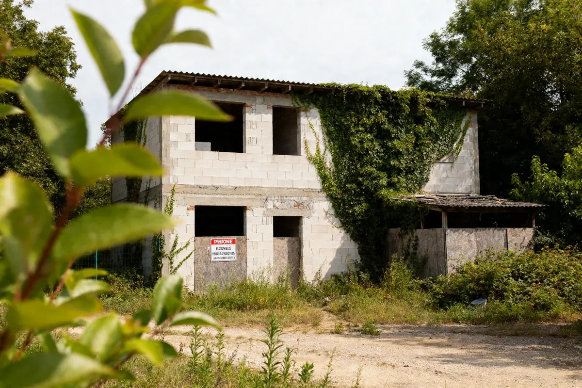 Bâtiment abandonné envahi par la végétation, exemple de construction illégale de plus de 10 ans