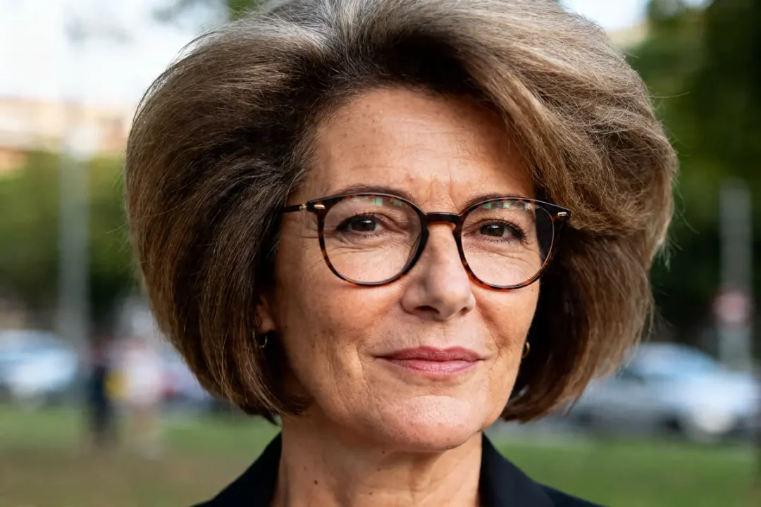 Femme de 50 ans avec lunettes et coupe de cheveux volumineuse en extérieur