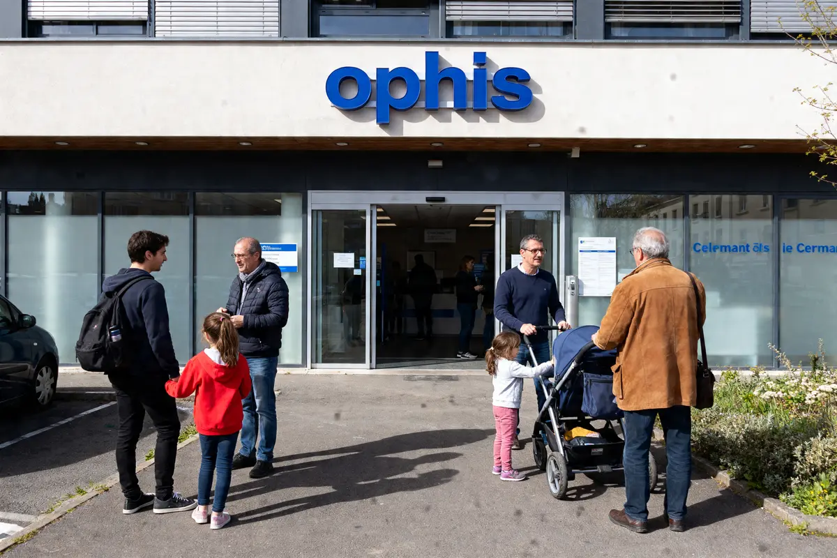 Façade de l'agence ophis Clermont Ferrand avec plusieurs personnes discutant à l'entrée principale