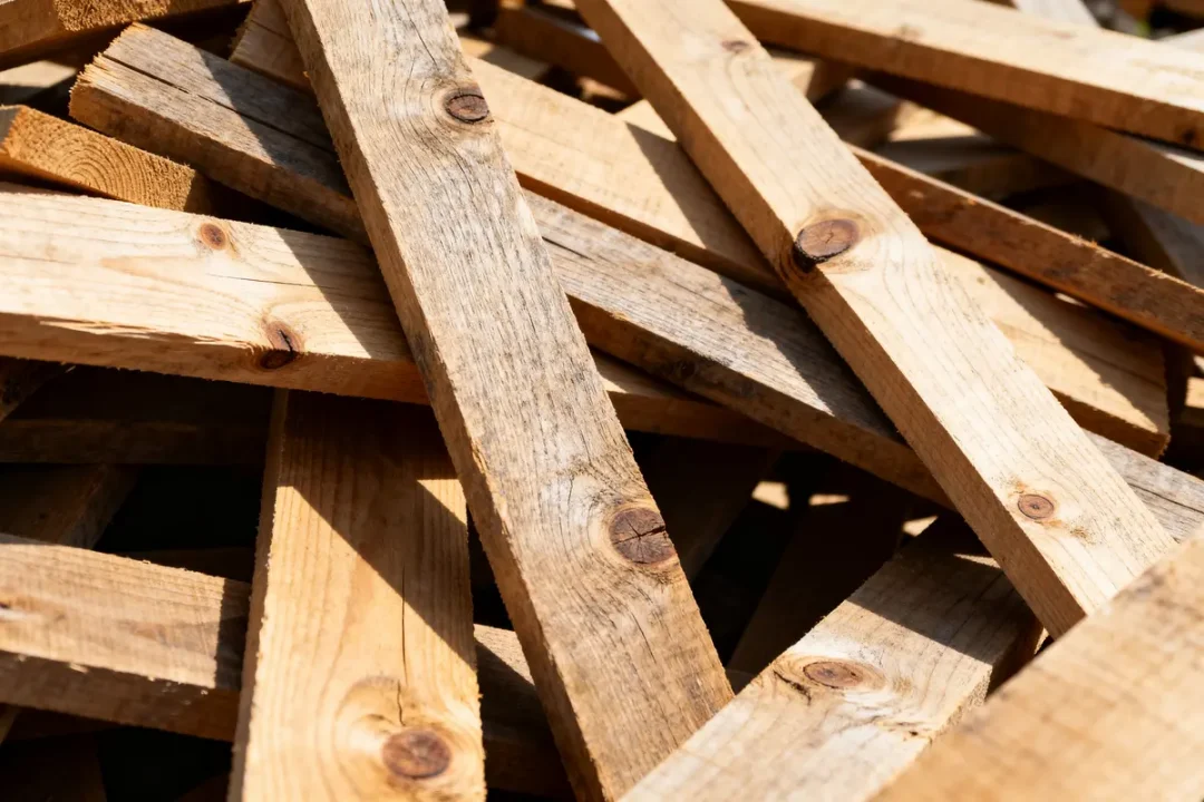Planches empilées en bois brut avec nœuds montrant stère de bois prix abordable
