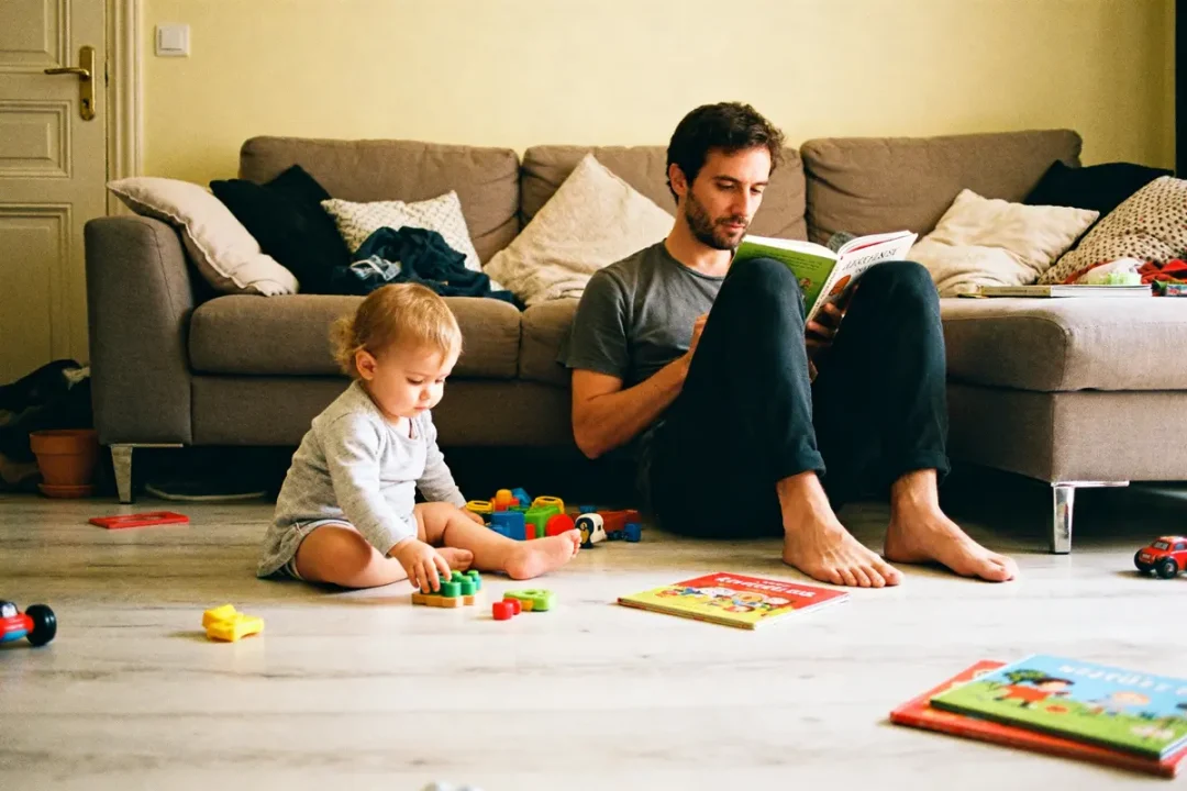 Papa lit, enfant joue avec des blocs, moment de complicité familial pour Petit Pas Parental blog