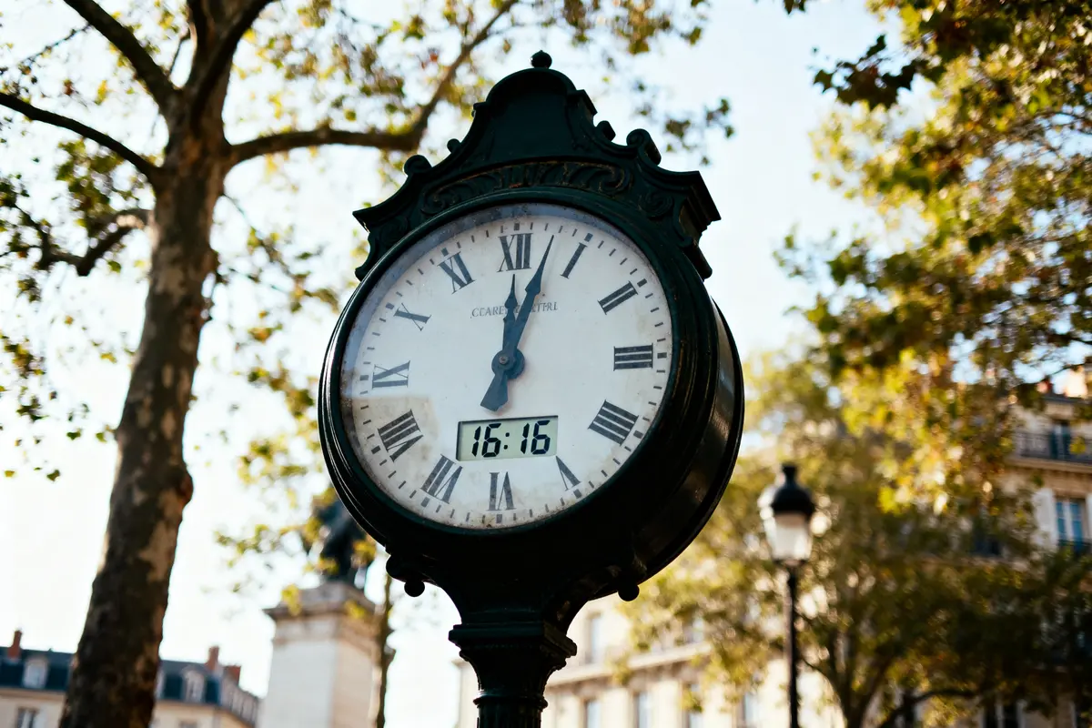 Horloge de rue indiquant 16h16, entourée d'arbres, signification de 16h16 mise en valeur