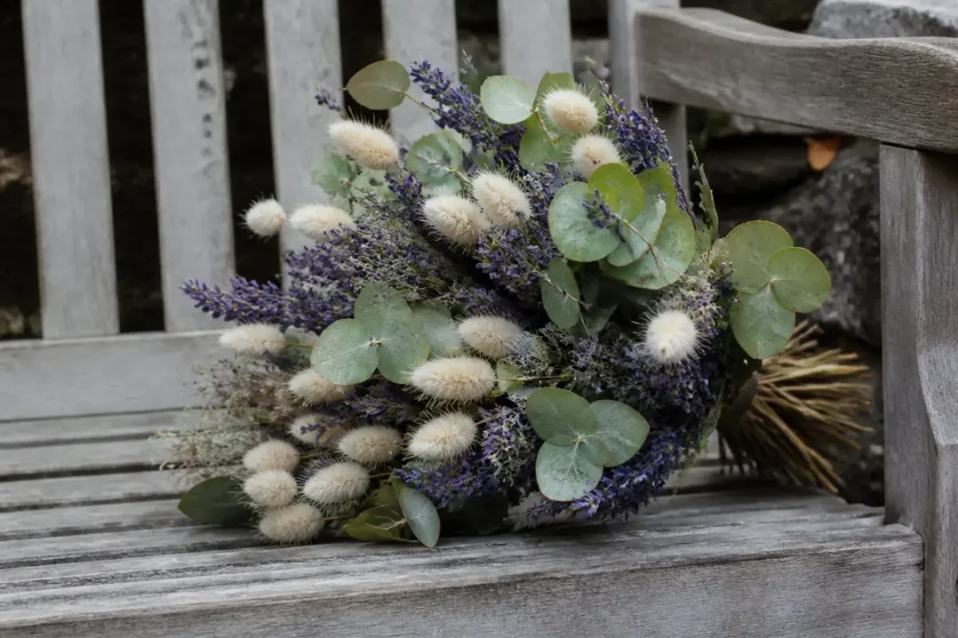 Bouquet de fleurs séchées avec eucalyptus et lavande sur un banc en bois gris