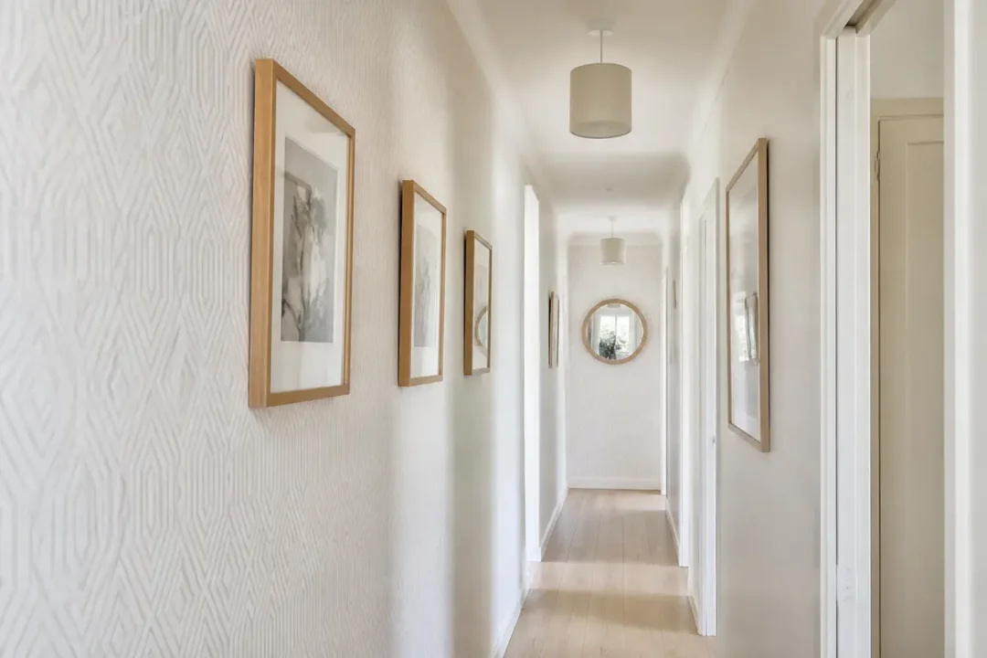 Couloir bien éclairé avec cadres en bois, exemple de décoration des couloirs moderne et épurée
