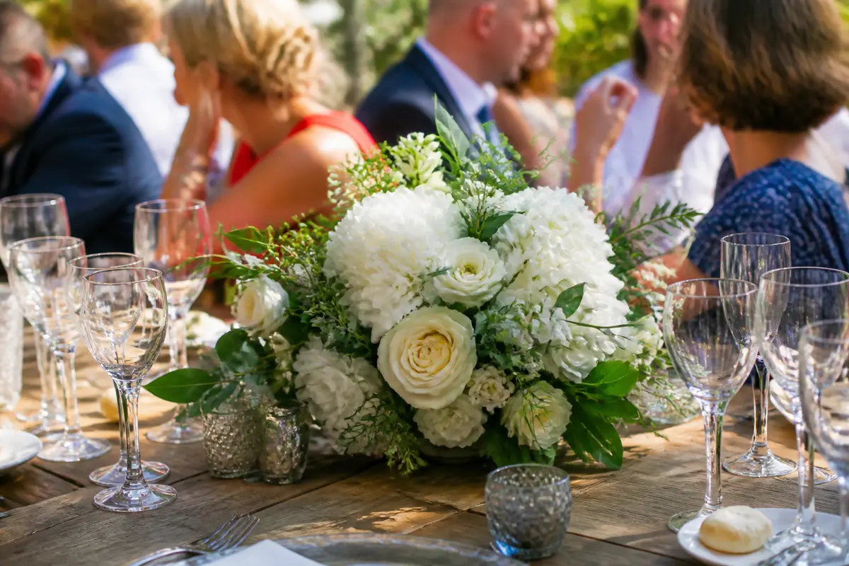 Bouquet de fleurs blanches pour décoration de table de mariage en extérieur élégant.