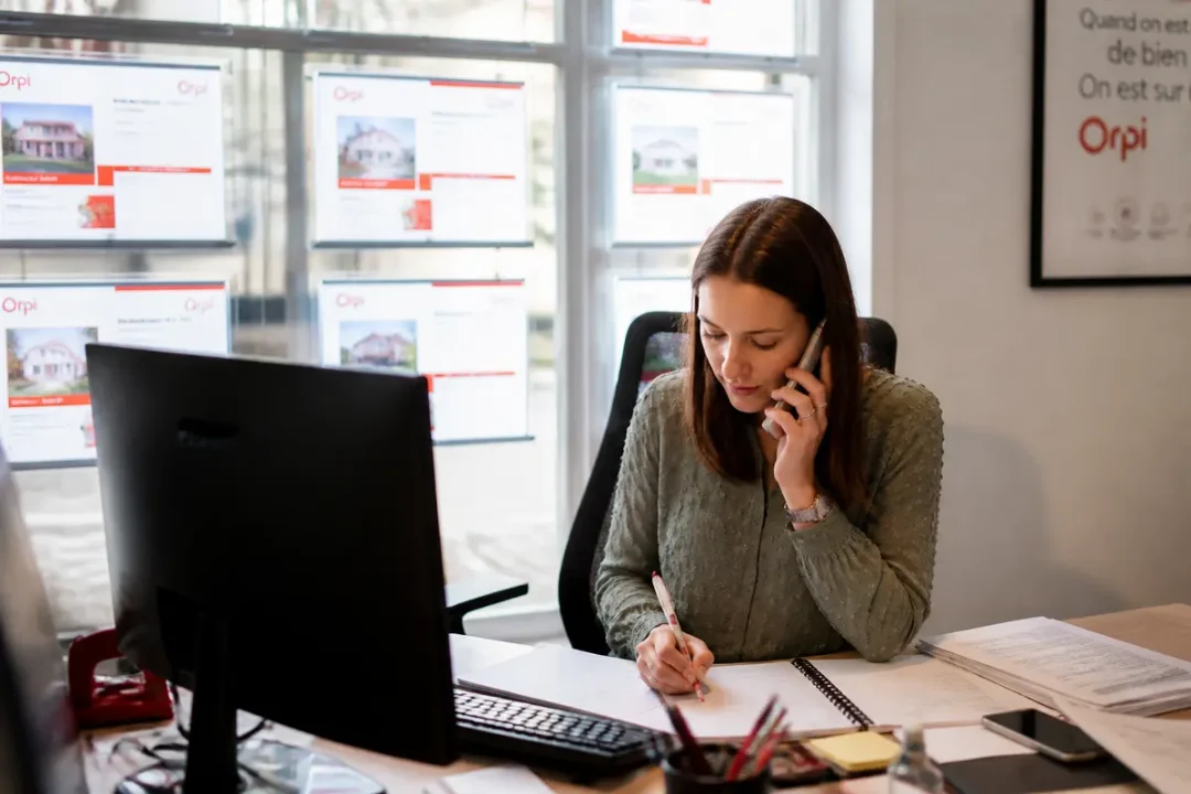 Agent immobilier travaillant au bureau, discutant avec un client concernant un contrat Socorpi.