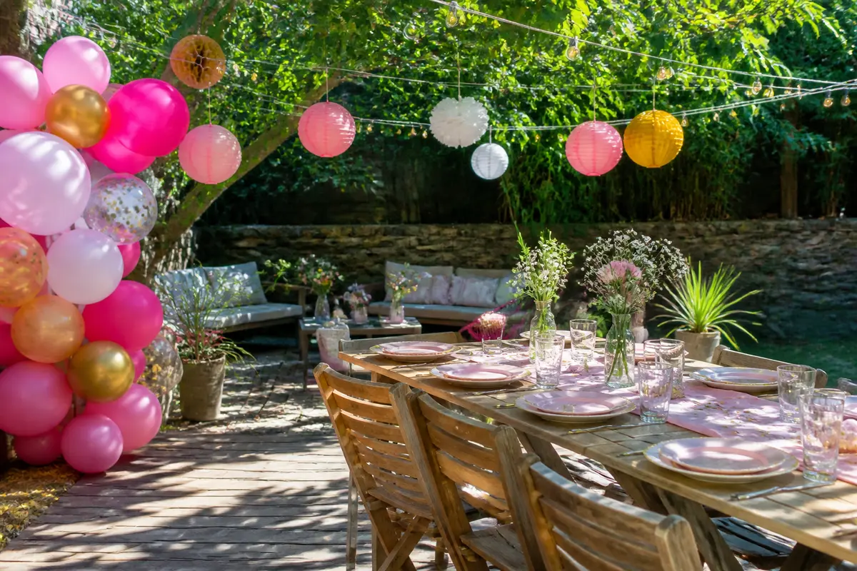 Table de jardin décorée avec ballons et lampions, idéale pour une décoration d'EVJF.
