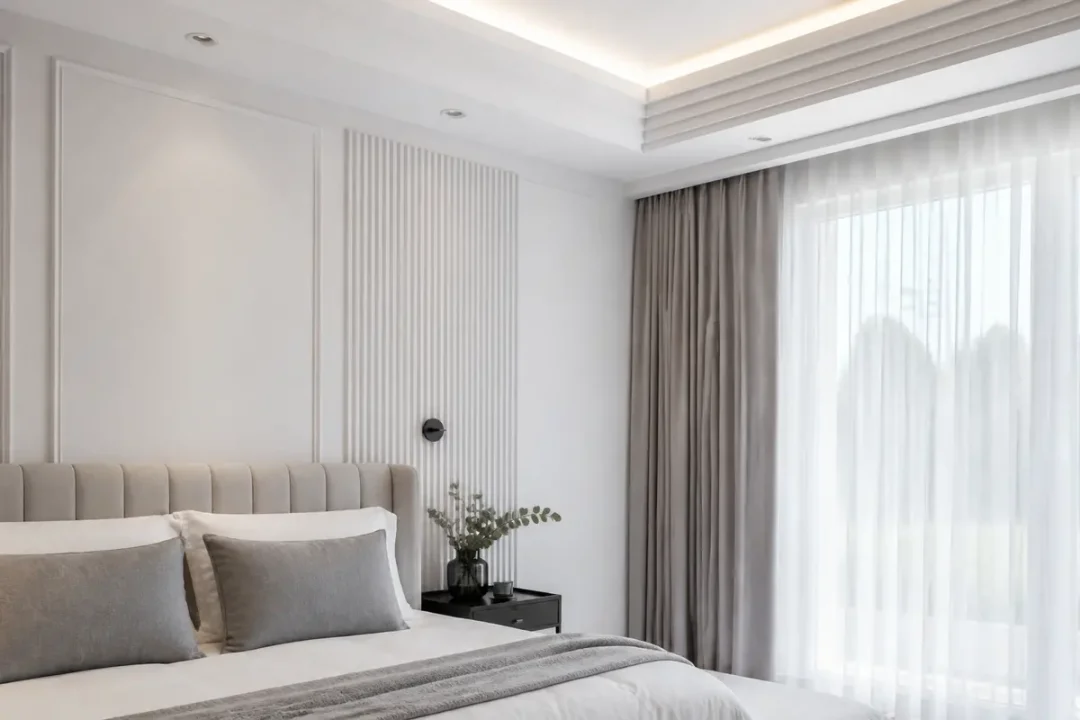 Chambre élégante avec moulures murales oracdecor et rideaux gris dans la lumière naturelle